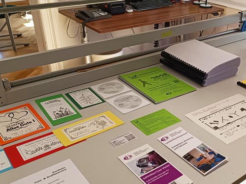 Im Bereich Audio-, Text- und Grafikservice werden taktile Karten, Flyer und Druckerzeugnisse mit Braille vorgestellt.