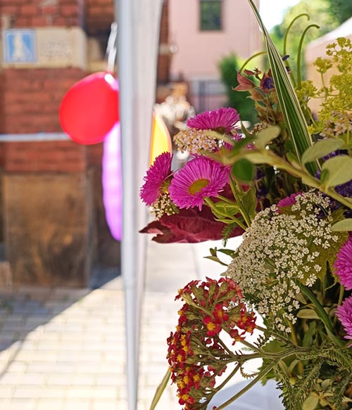 Ein sommerlicher Tag, Blick vorbei an einem hübschen Blumenstrauß und Ludtballons auf unseren Eingangsbereich.
